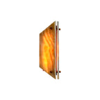Clérachic stone wall sconce lit on a white background, the jade panel glowing amber over its brass mounting bar.