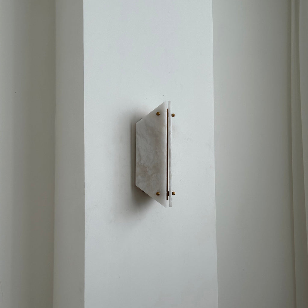 Unlit Clérachic alabaster sconce seen from the side, sitting only a few centimetres proud of a white wall.