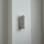 Unlit Clérachic alabaster sconce seen from the side, sitting only a few centimetres proud of a white wall.
