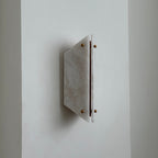 White alabaster panels and brass ball finials on the Clérachic wall sconce, switched off against a plain wall.
