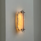 Lit Clérachic stone sconce on a corner wall, warm light spilling above and below the glowing alabaster panel.