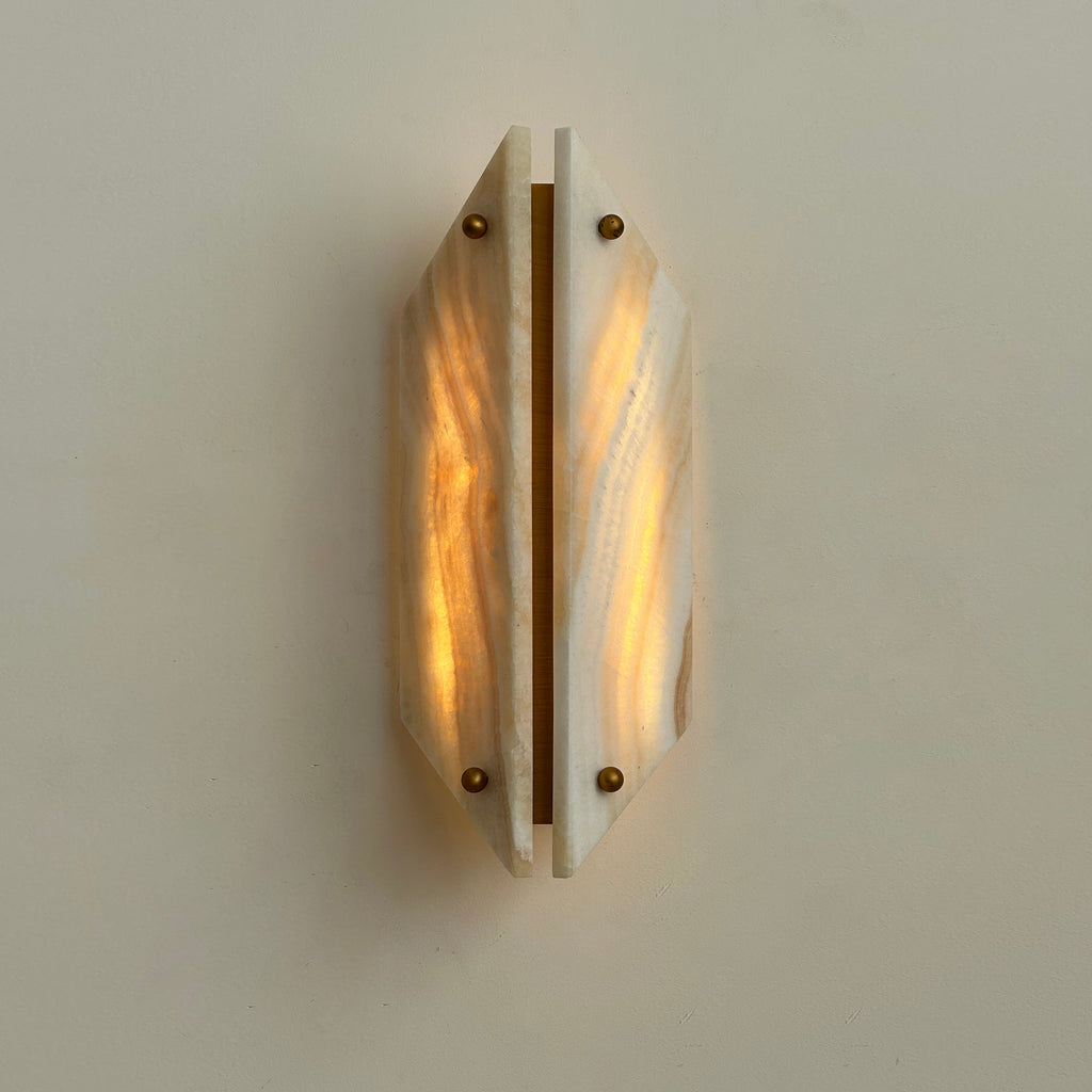 Clérachic jade wall sconce lit head on, both honey-veined panels glowing warm around a central brass bar.