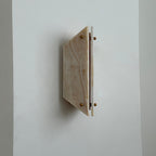 Side view of the unlit Clérachic jade sconce, the angled stone panel projecting a hand's width from the wall.
