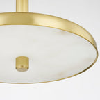 Close detail of the Clérachic Alabaster Pendant Light: the brass finial set into the veined alabaster disc inside the polished rim.