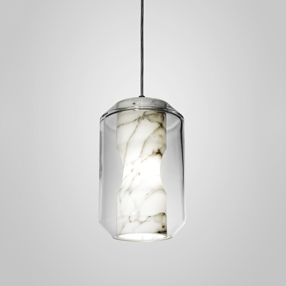 Lit tall cylinder from the Clérachic Alabaster Pendant Light range, its open base casting a bright ring of light below the veined stone column.