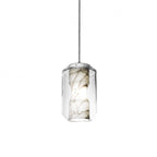 Unlit, the Clérachic Alabaster Pendant Light reads as a pale grey-veined stone column suspended inside clear faceted glass on its cable.