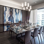 A nine-piece run of Clérachic Alabaster Pendant Lights lit over a set dining table, against a blue agate stone wall panel.
