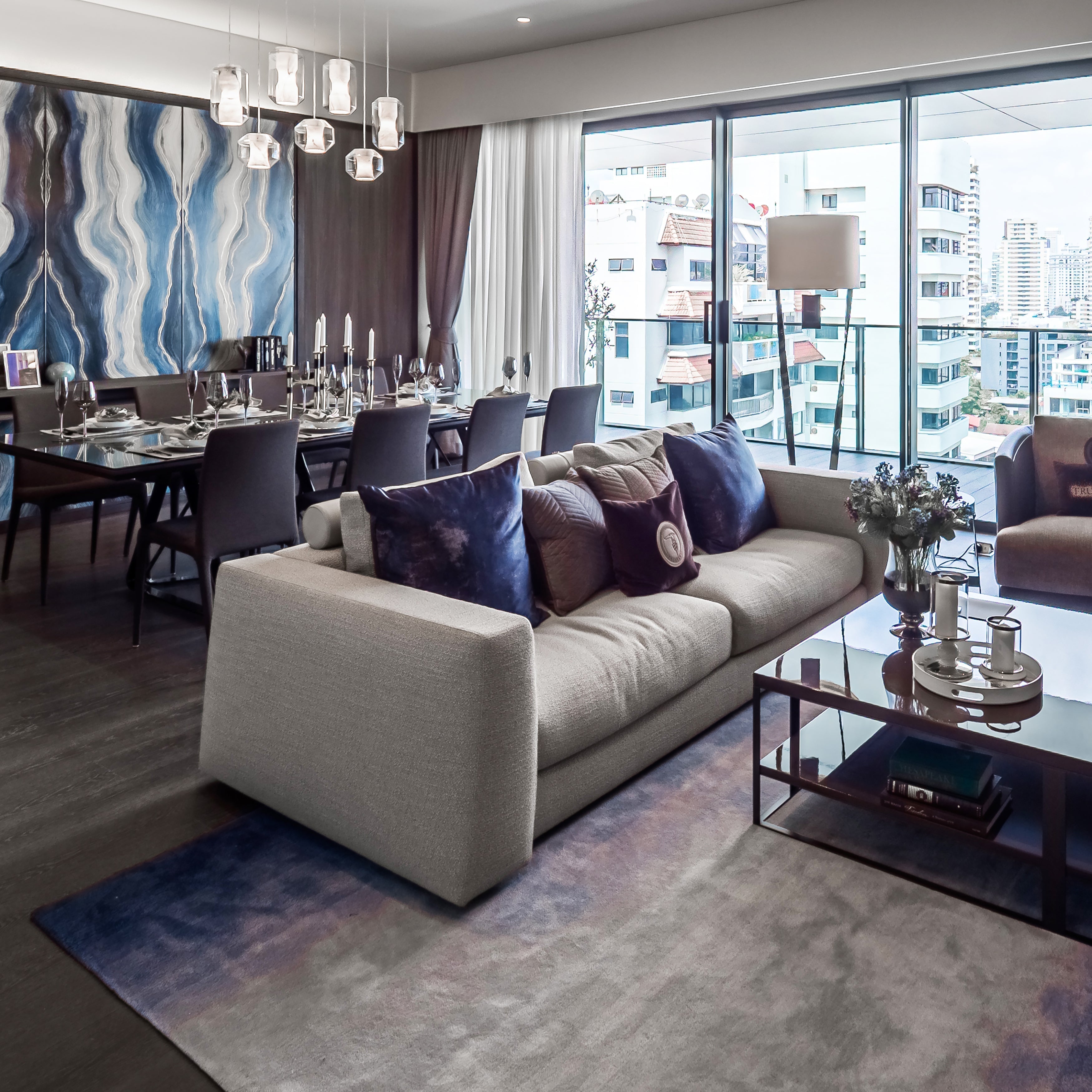 Open-plan view of Clérachic Alabaster Pendant Lights over the dining table, seen across the sofa in a modern apartment.