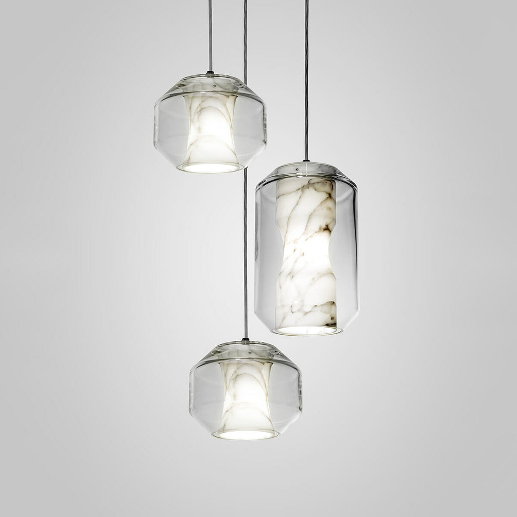 Both sizes together: two barrels and one tall cylinder of the Clérachic Alabaster Pendant Light lit in a staggered studio group.