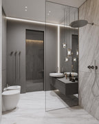 Three Clérachic Alabaster Pendant Lights hung in a row over a floating washstand against a book-matched marble wall.