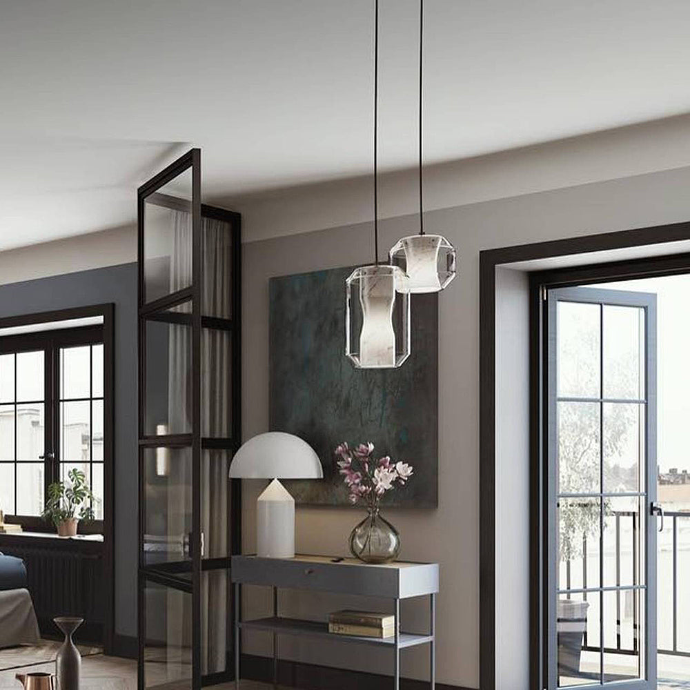 Two Clérachic Alabaster Pendant Lights on black cables in a hallway, hung above a console of magnolias by the balcony doors.