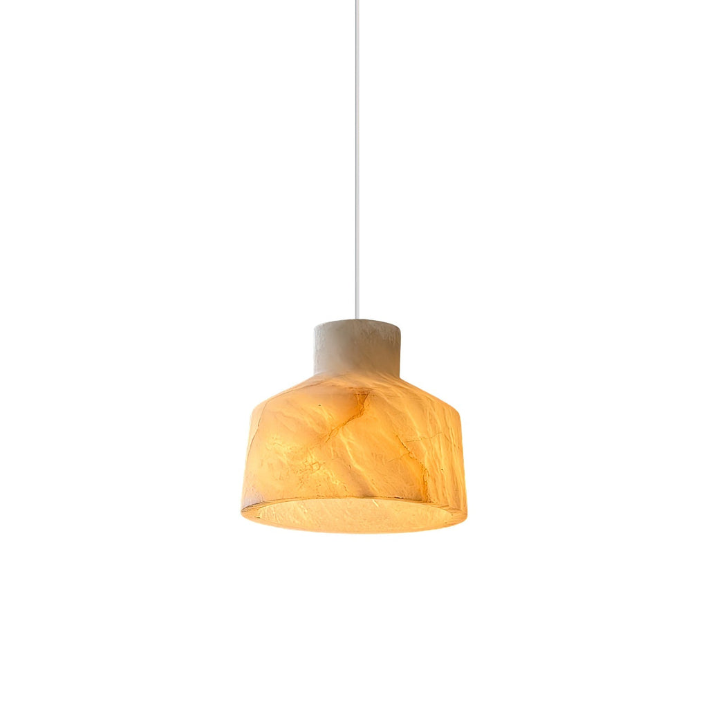 Studio view of the Clérachic Alabaster Pendant Light, its lit shade glowing amber through the veined stone on a white cord.