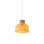 Studio view of the Clérachic Alabaster Pendant Light, its lit shade glowing amber through the veined stone on a white cord.
