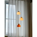 Clérachic Alabaster Pendant Light cluster lit in front of a floor-to-ceiling window, three shades falling in a staggered line.