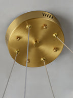 The brass ceiling canopy of the Clérachic Alabaster Ring Chandelier, vent slots and cable grips holding the clear suspensions.