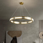 Clérachic Alabaster Ring Chandelier hung from its canopy in a concrete-walled room above a textured stone artwork.
