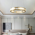 Clérachic Alabaster Ring Chandelier glowing over a bed in a panelled bedroom, recessed downlights washing the wall behind.