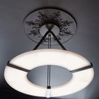 Looking up at the Clérachic Alabaster Ring Chandelier, the bright ring floating below a carved plaster ceiling rose.