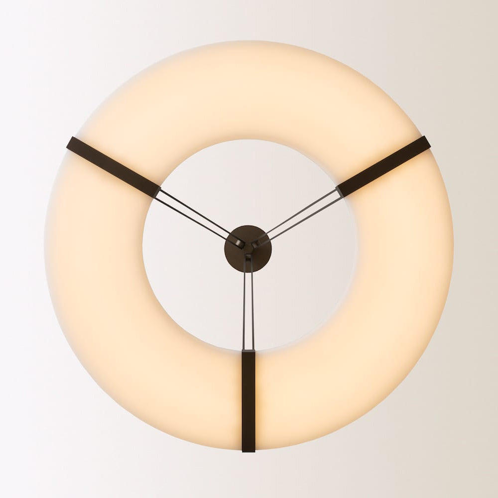 Underside view of the Clérachic Alabaster Ring Chandelier, three bronze straps meeting a central hub inside the glowing ring.