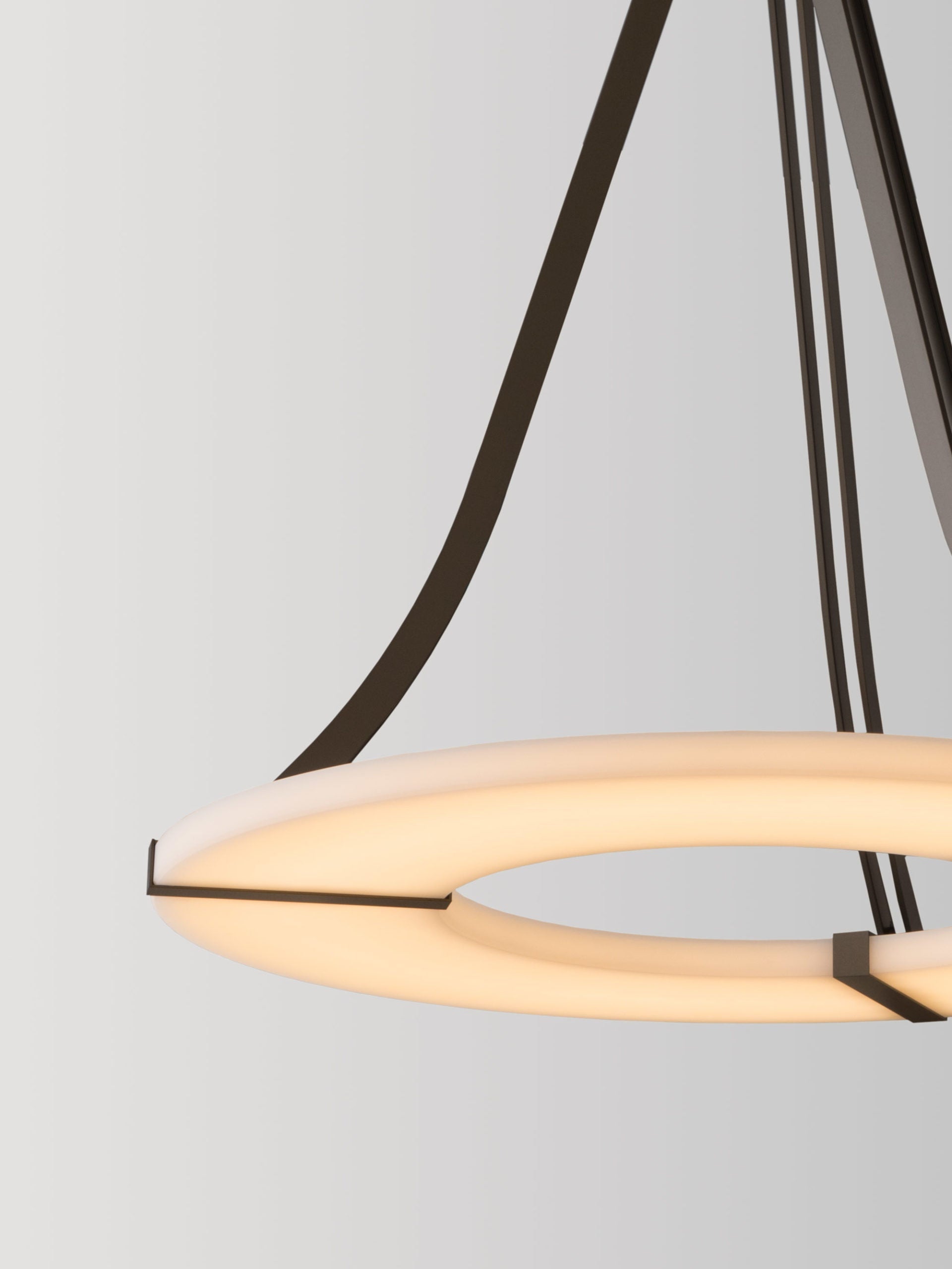 Clérachic Alabaster Ring Chandelier in close-up, one curved bronze arm reaching down to the warm rim of the stone ring.
