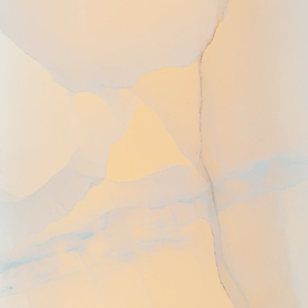 Stone macro of the Clérachic Alabaster Ring Chandelier, backlighting drawing out cream and blue-grey veins in the natural alabaster.
