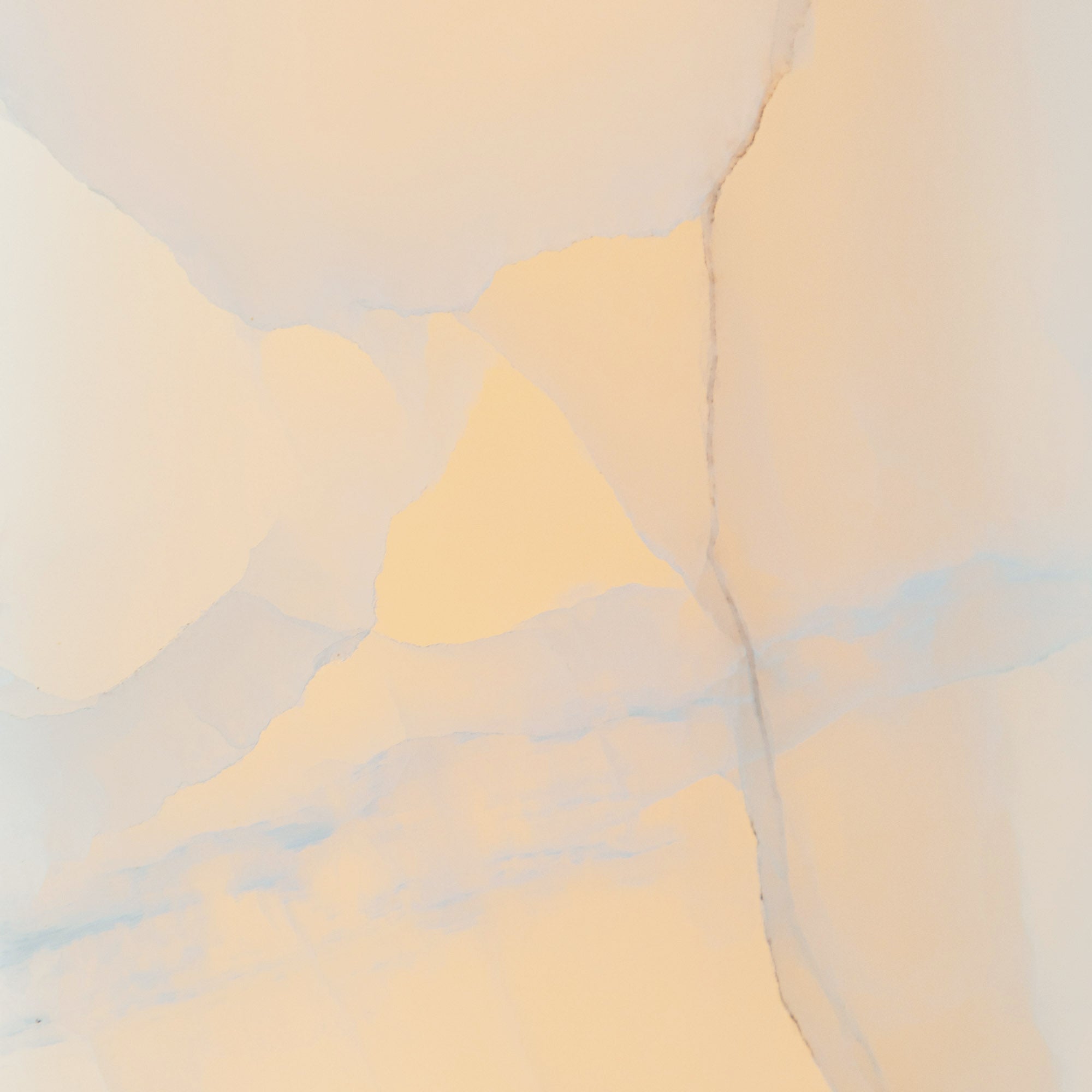 Stone macro of the Clérachic Alabaster Ring Chandelier, backlighting drawing out cream and blue-grey veins in the natural alabaster.