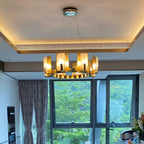 Clérachic Alabaster Ring Chandelier installed in a real home, glowing warm above a kitchen window that opens onto green hills.