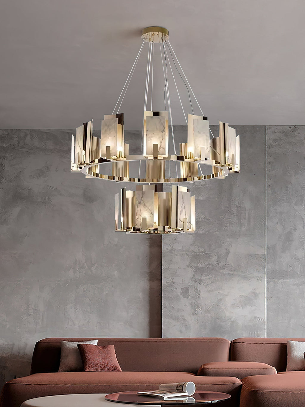 Two-tier Clérachic Alabaster Ring Chandelier above a terracotta sofa, filling the height of a polished concrete wall.