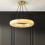 Clérachic Alabaster Ring Chandelier lit against dark panelled joinery, four black cords running up to the brass canopy.