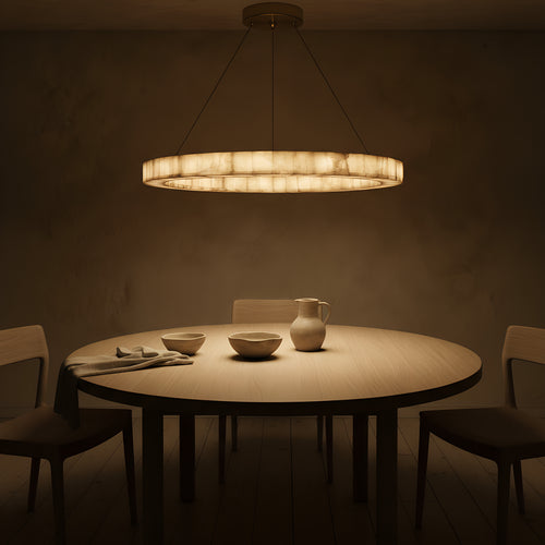 Clérachic single-ring alabaster chandelier lit over a round oak dining table at night, the calcite glowing from within and laying a warm pool across the table