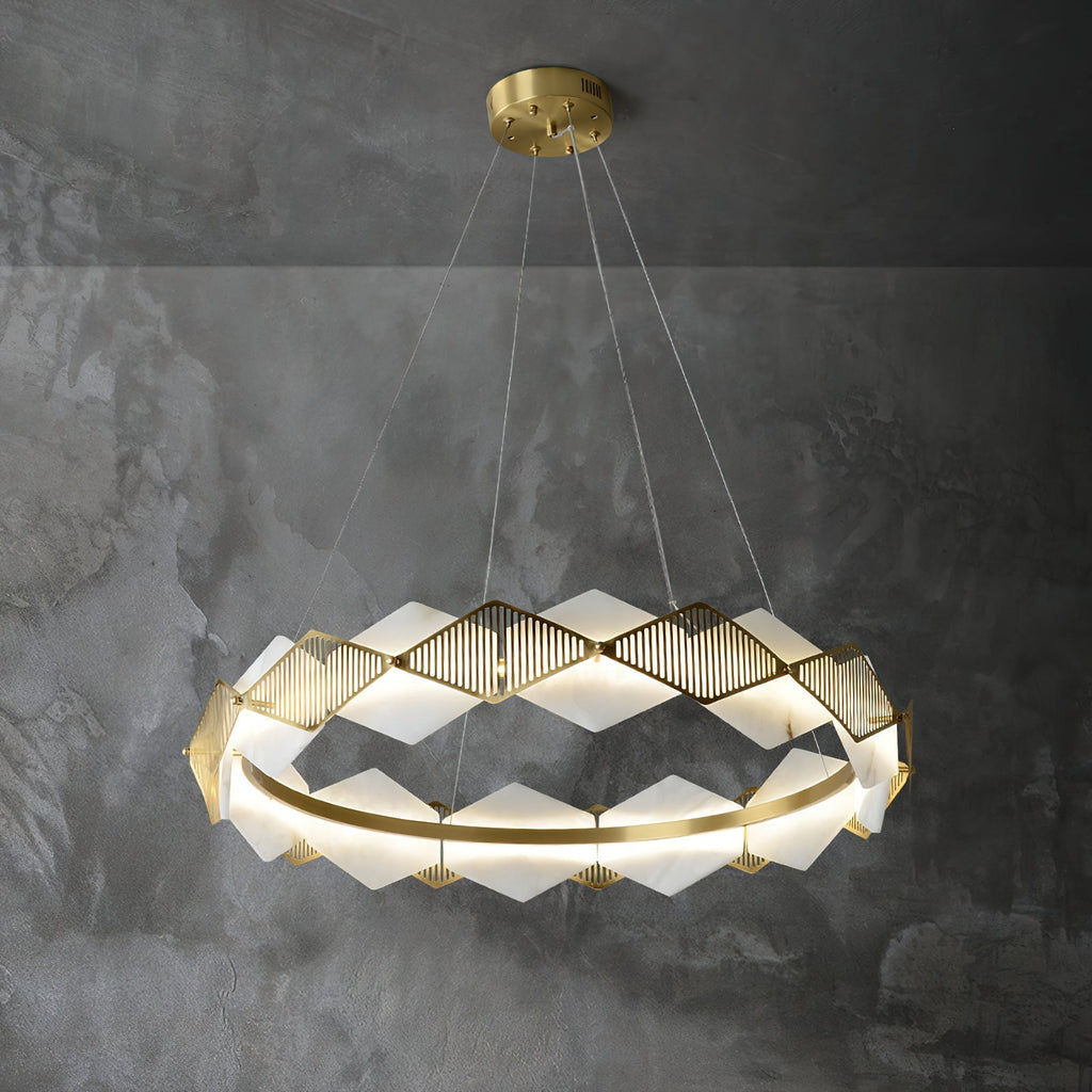 Clérachic Alabaster Ring Chandelier glowing against a dark concrete wall, the brass fins raking the light into fine lines.