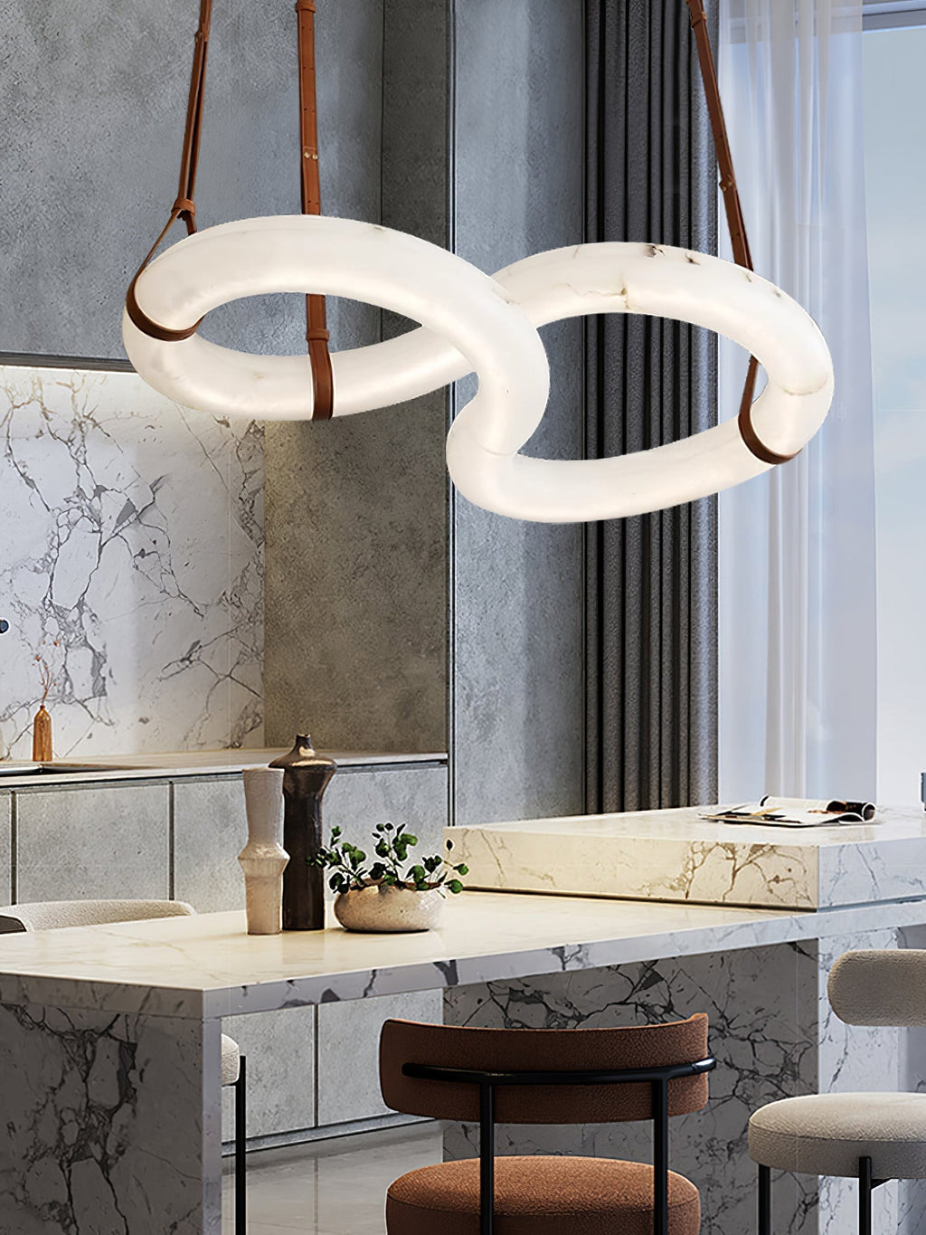 Clérachic Alabaster Ring Chandelier glowing over a marble kitchen island, sheer curtains and bar stools in the background.