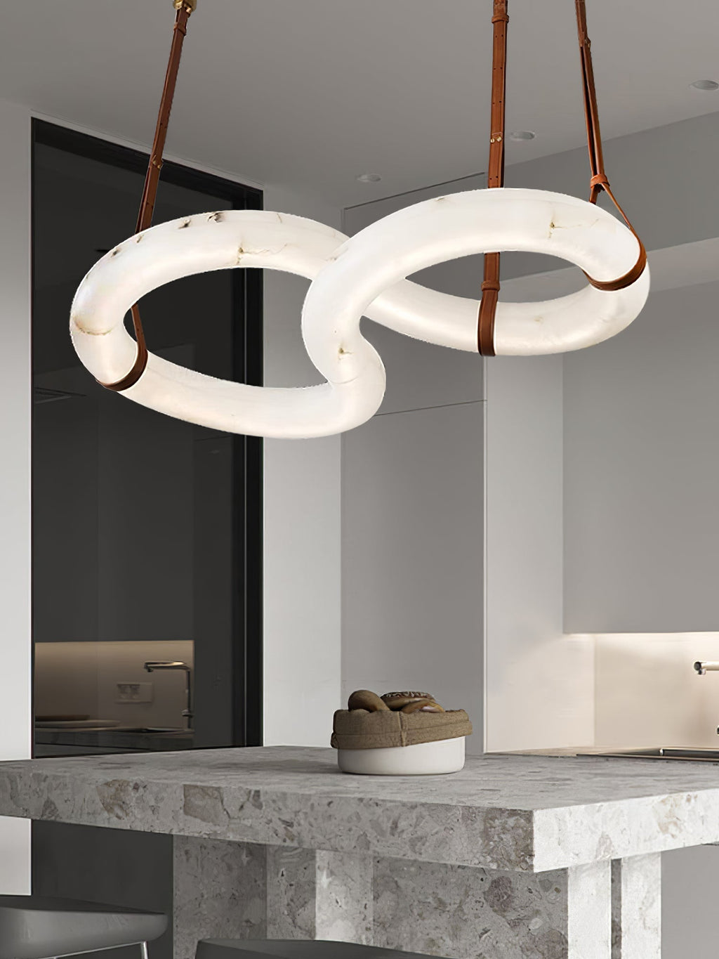 Clérachic Alabaster Ring Chandelier above a rough-cut stone kitchen island, the two rings lit and level with each other.