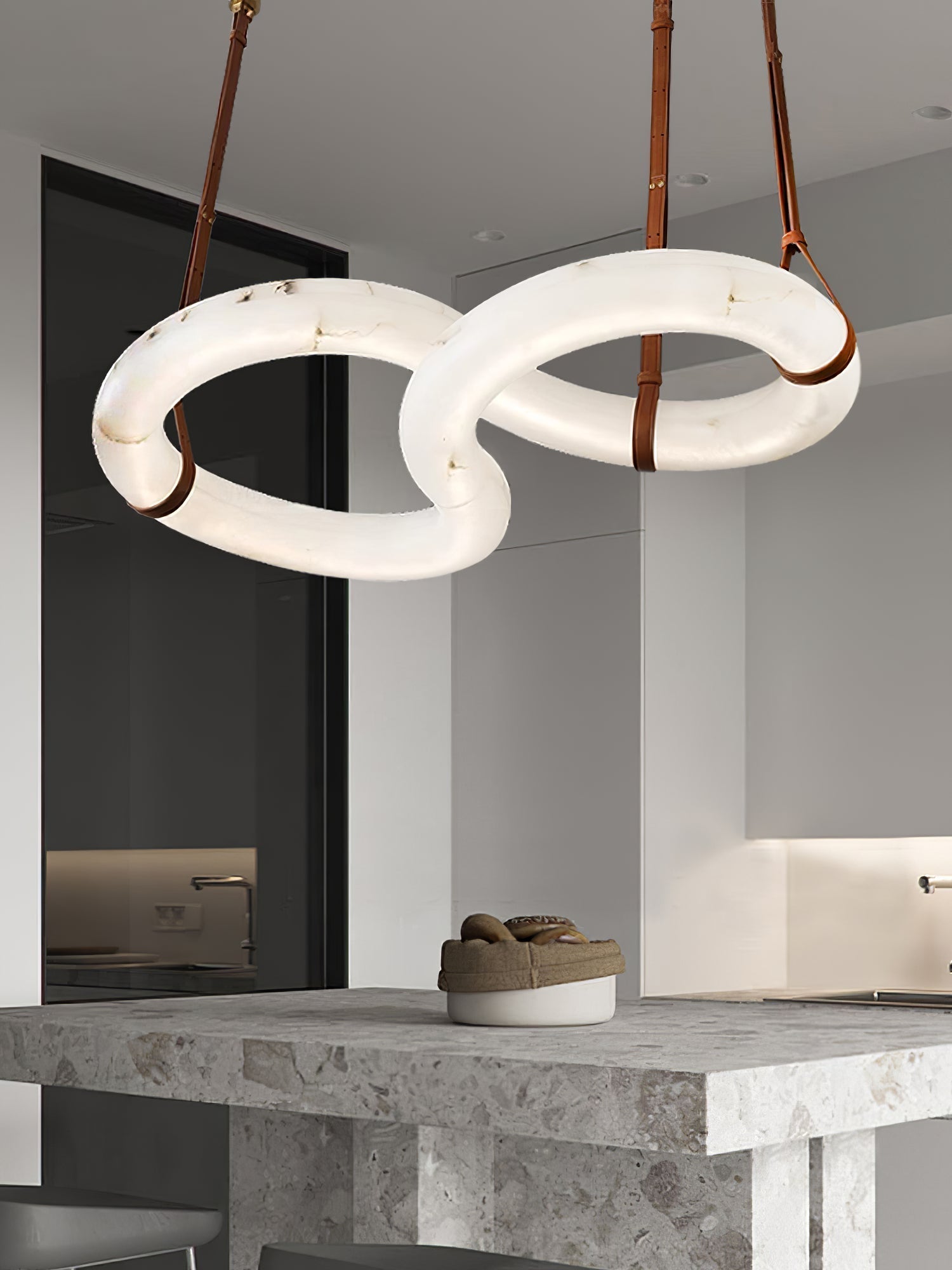 Clérachic Alabaster Ring Chandelier above a rough-cut stone kitchen island, the two rings lit and level with each other.