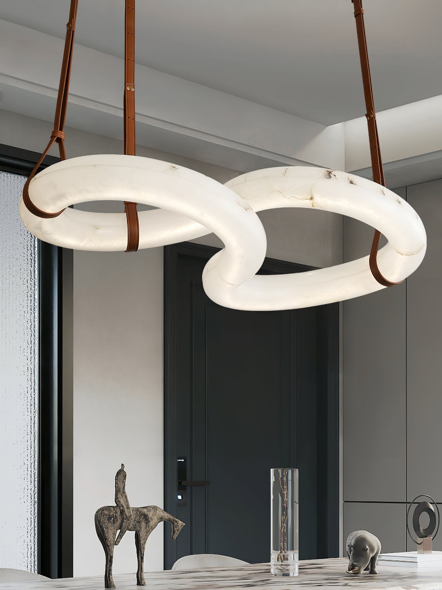 Close view of the Clérachic Alabaster Ring Chandelier above a marble table, a bronze horse sculpture standing beneath it.