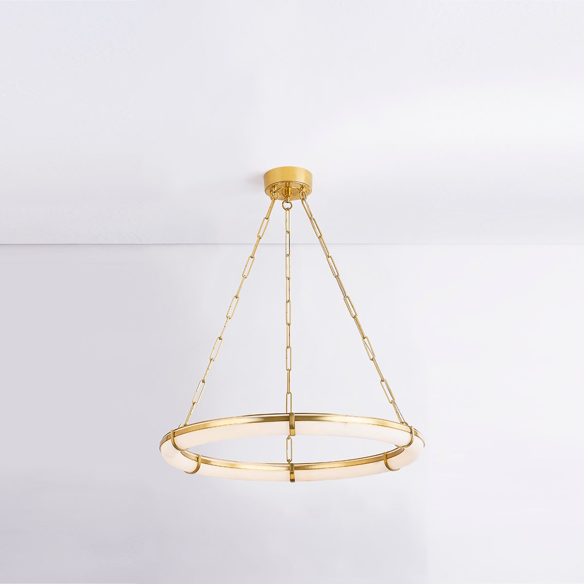 Clérachic Alabaster Ring Chandelier hung from a white ceiling in a bright room, floating clear of the wall behind it.