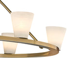 Three alabaster cones on the Clérachic ring chandelier, their veining catching the light above the brushed gold rim.