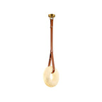 Clérachic Alabaster Ring Pendant Light shown on white: brass canopy, tan leather strap and pale stone ring seen at an angle.