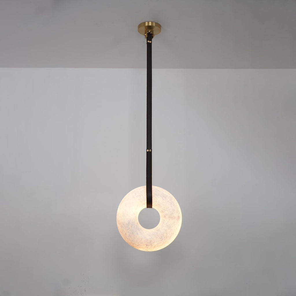 A single dark strap drops the Clérachic Alabaster Ring Pendant Light down a grey wall, the ring lit from within.
