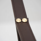 Detail of the stitched leather strap on the Clérachic Alabaster Ring Pendant Light, closed with two brass rivets.