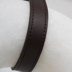 Close detail of the Clérachic Alabaster Ring Pendant Light where the stitched brown strap crosses the white alabaster.