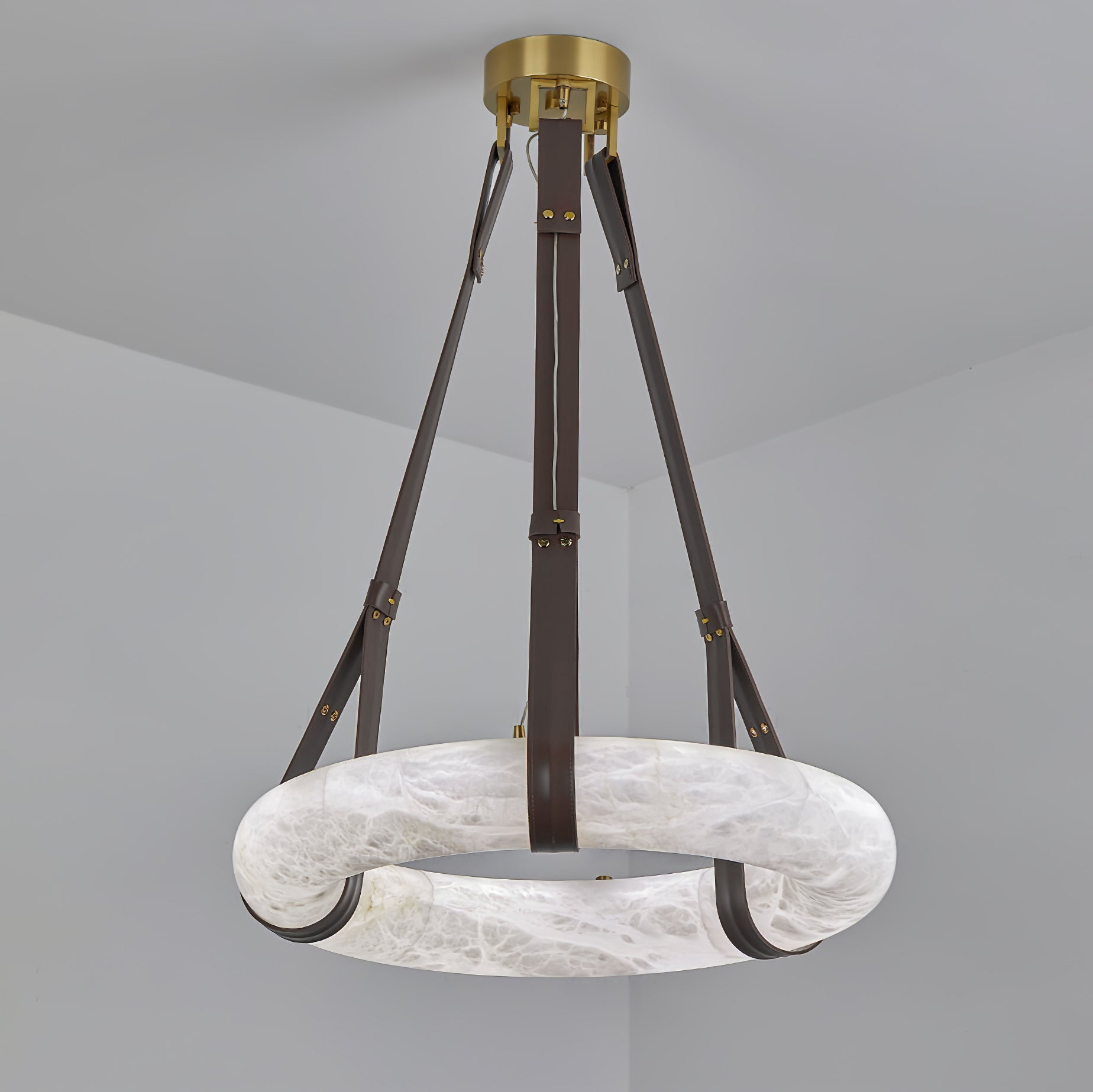 The Clérachic Alabaster Ring Pendant Light hung unlit, its dark brown straps meeting at the round brass canopy overhead.