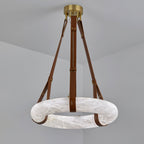 Clérachic Alabaster Ring Pendant Light shown with tan brown leather straps, the pale stone hoop hanging flat below the brass canopy.
