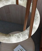 Looking up through the Clérachic Alabaster Ring Pendant Light in a wood-panelled room, its open centre framing the table below.
