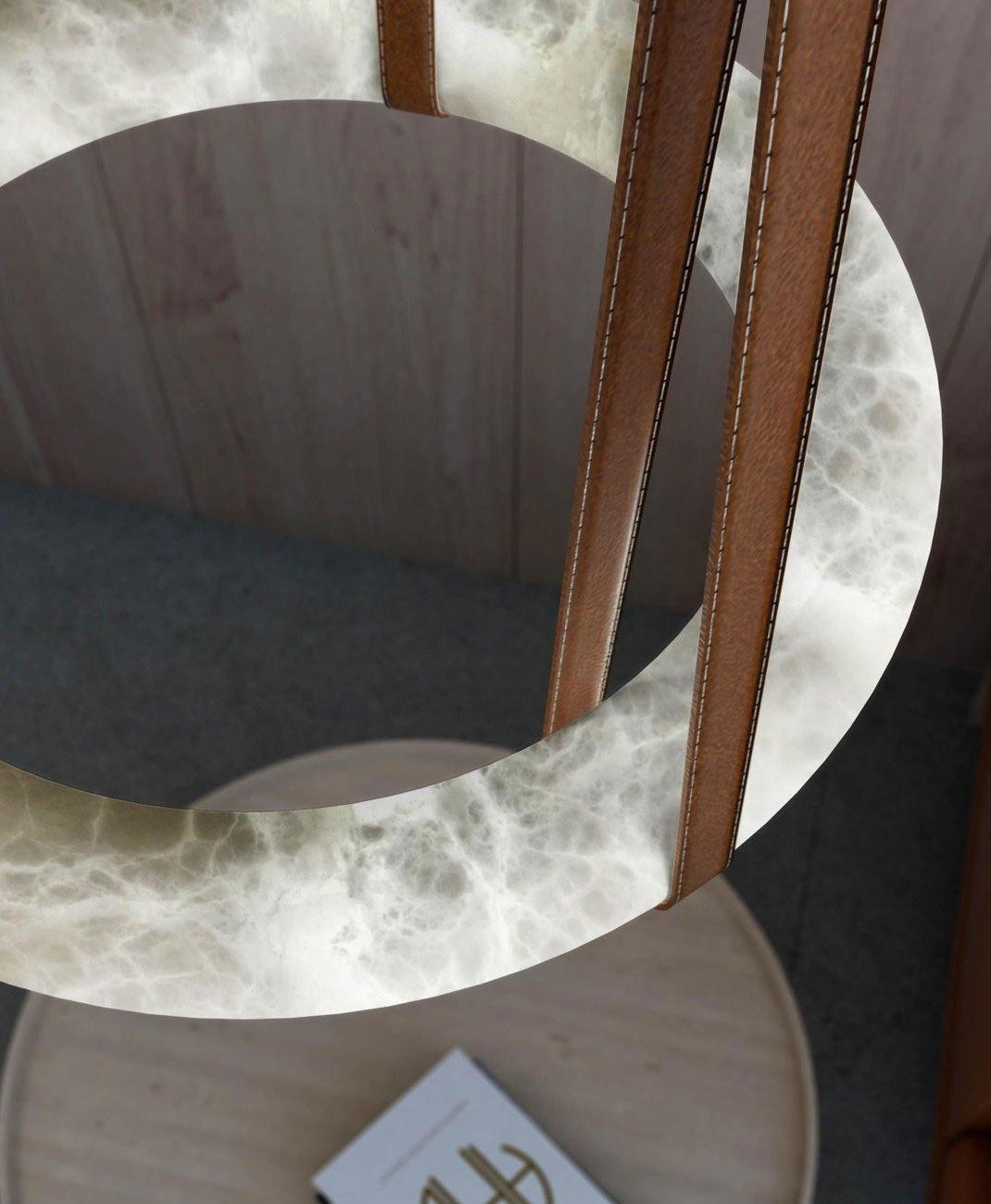 Looking up through the Clérachic Alabaster Ring Pendant Light in a wood-panelled room, its open centre framing the table below.