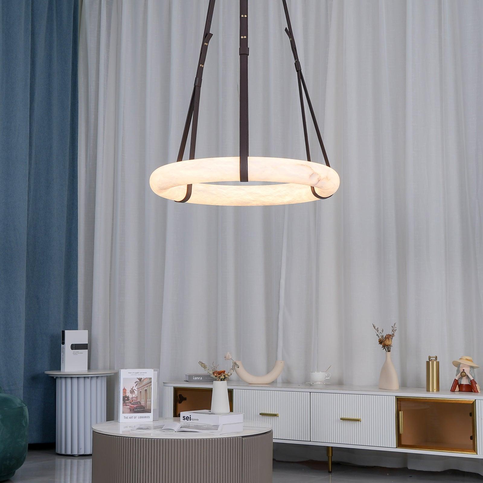 Clérachic Alabaster Ring Pendant Light lighting a living room above a round coffee table, with a white sideboard along the wall.