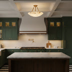 The Clérachic alabaster semi-flush light hangs above a marble kitchen island, with dark green cabinets and a white range hood behind.