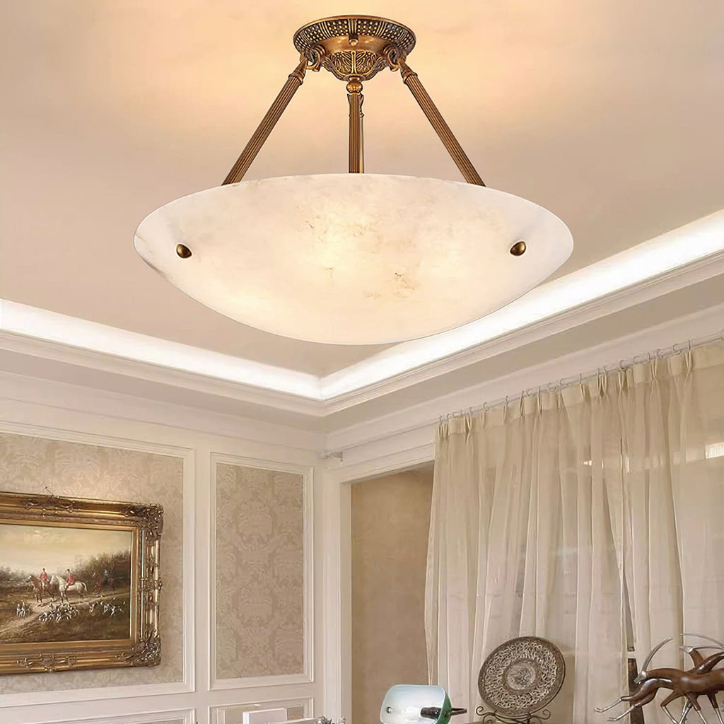 From below, a Clérachic alabaster bowl light with brass arms, set in a cove ceiling with a framed landscape beyond.