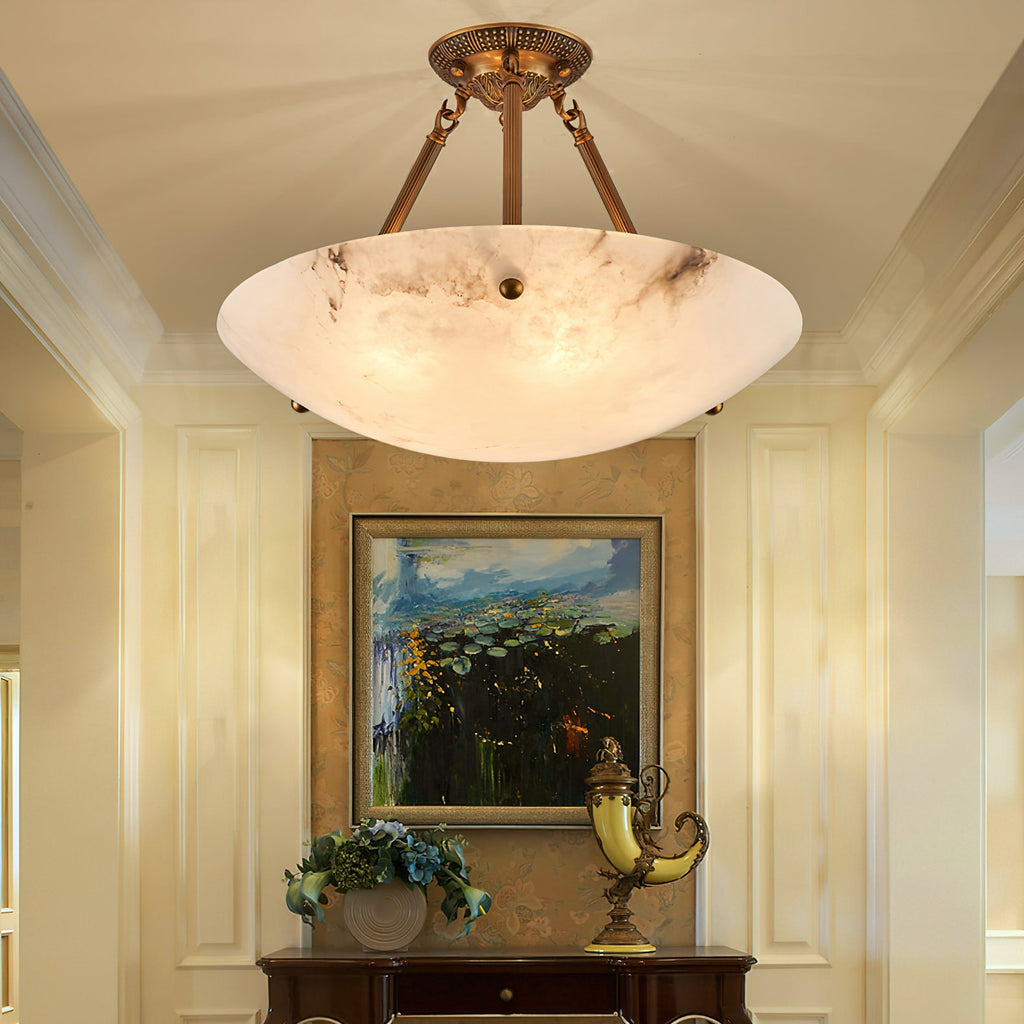A Clérachic alabaster ceiling light with dark marbling hangs above a console table and a framed painting of water lilies.