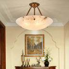 This Clérachic alabaster ceiling light is lit above a wooden sideboard with a framed autumn landscape and a stag figure.